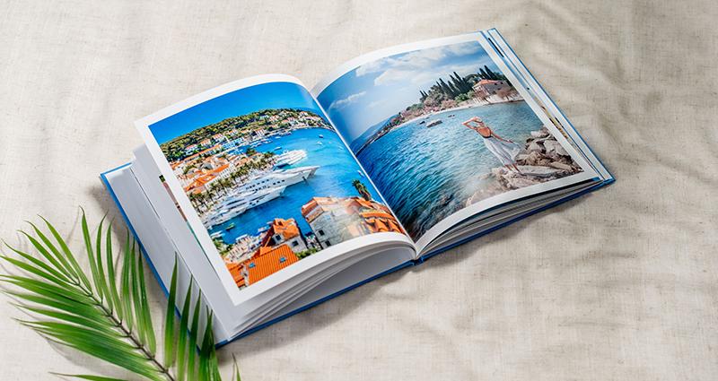 Ein offenes Fotobuch aus dem Urlaub, voller Sommererinnerungen.