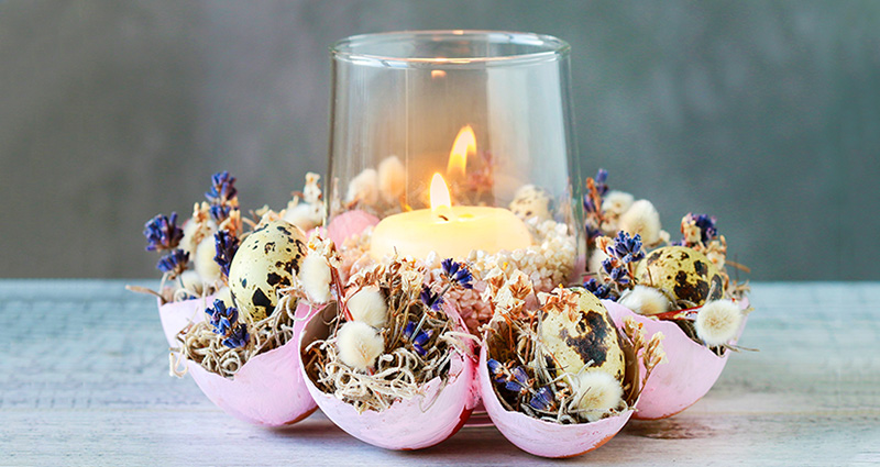 Easter candleholder made of egg shells, moss, catkins and small flowers.