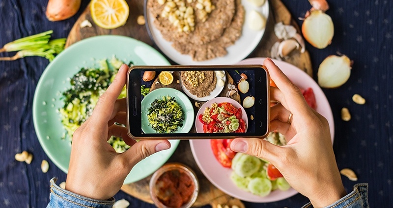 Foto jídla na třech barevných talířích pořízenýcchpomocí smartphonu, letecká fotografie