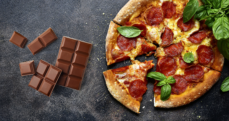 Pizza verdeeld in stukken en chocolade