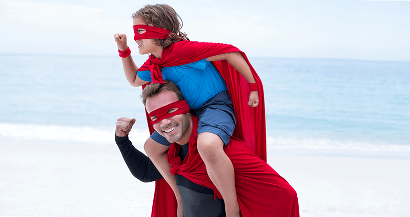Un padre con un bambino sulle spalle travestiti da Spiderman