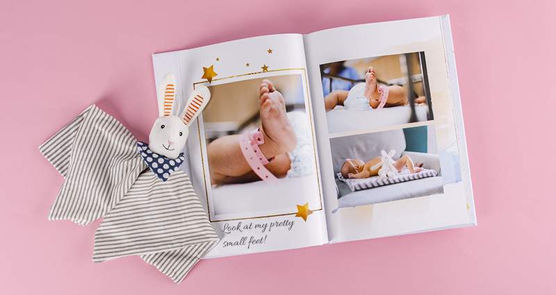Fotobuch mit Babybildern, daneben ein Kuscheltier