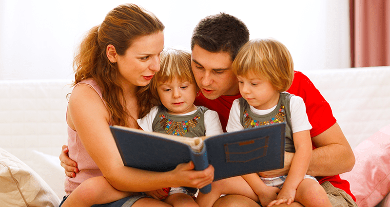 A family is flipping through a yearbook. Yearbook signing