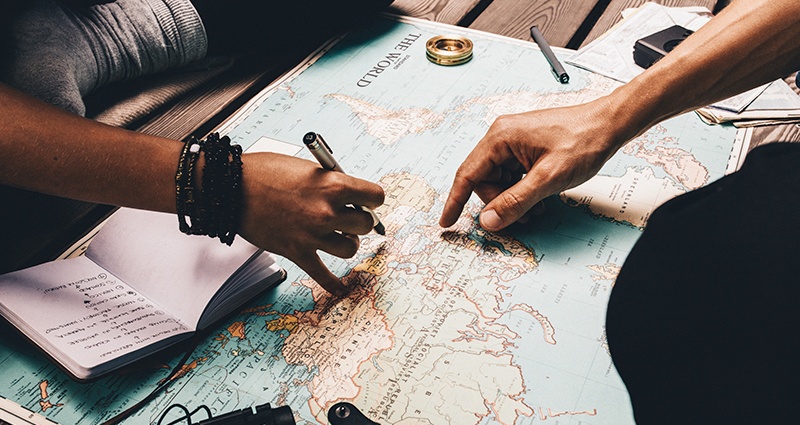 Couple planning their trip and writing down inspirational travel quotes