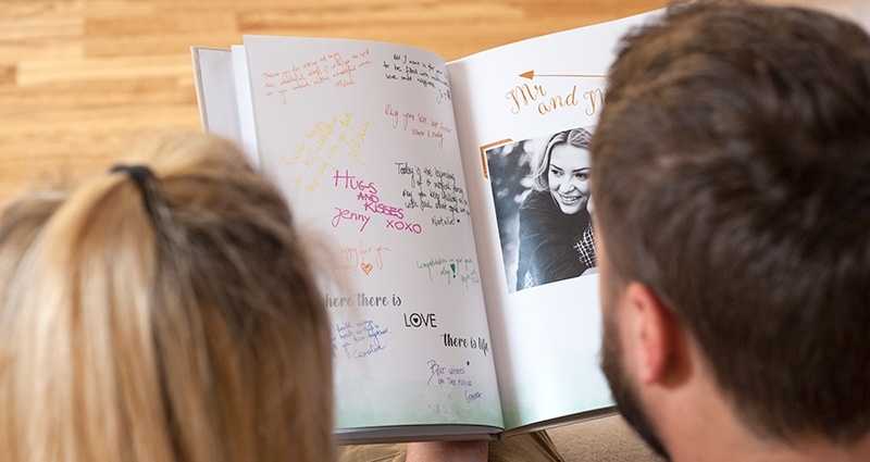 Un couple regardant livre d'or de leur mariage.