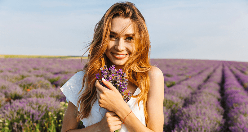 Una donna che tiene in mano dei rametti di lavanda durante un servizio fotografico all’aperto